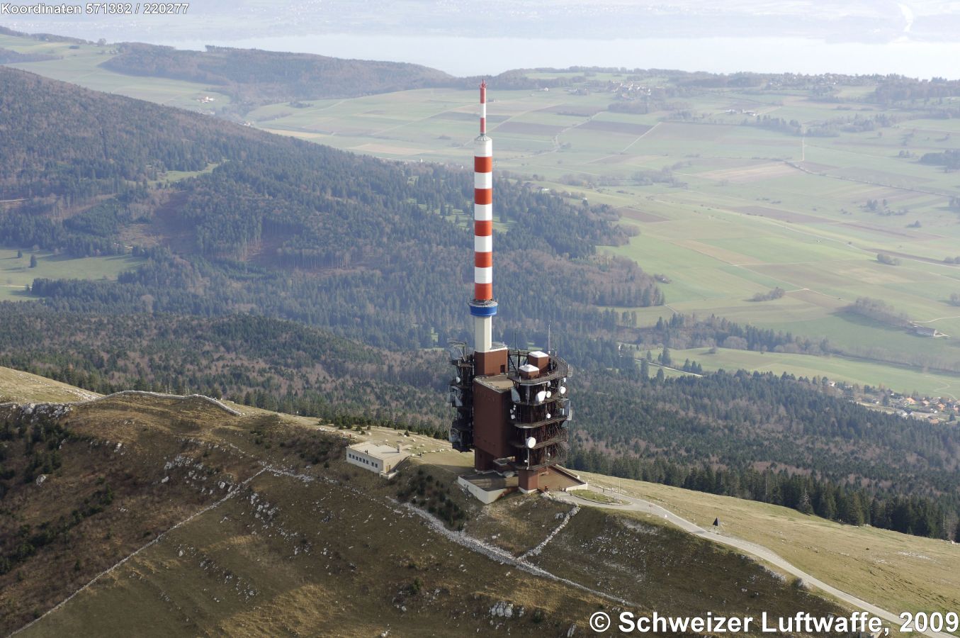 Chasseral (Position: 2'571'384.62, 1'220'333.94); 'L'antenne du Chasseral' (Station d'émission Nods Chasseral). - Im Bildhintergrund: Bielersee; Ortschaft Bildrand rechts: Nods. (Norden: linke untere Bildecke). - Der Sendeturm ist seit dem Umbau im Juni 2010 nur noch 114 Meter hoch. Die Antennen stehen für UKW und DAB.